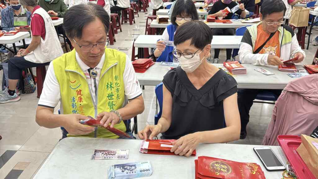 ▲林世賢市長協助將現金裝袋。（記者林明佑翻攝）