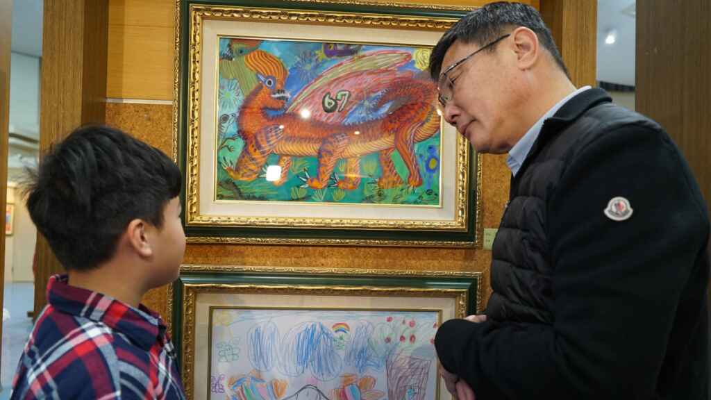 ▲鹿港鎮長許志宏細心聆聽孩子介紹作品。(記者林明佑攝)