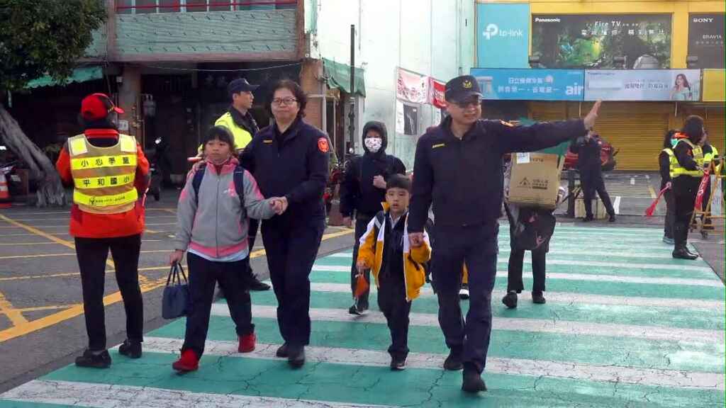 ▲今天是開學日，彰化縣警察局轄內8個分局同日全面啟動「護童專案」勤務，彰化分局分局長林英煌與婦幼警察隊隊長張彩鈴，於開學首日一同在彰化市平和國小門口，親自護送孩童過馬路。（記者林明佑攝）