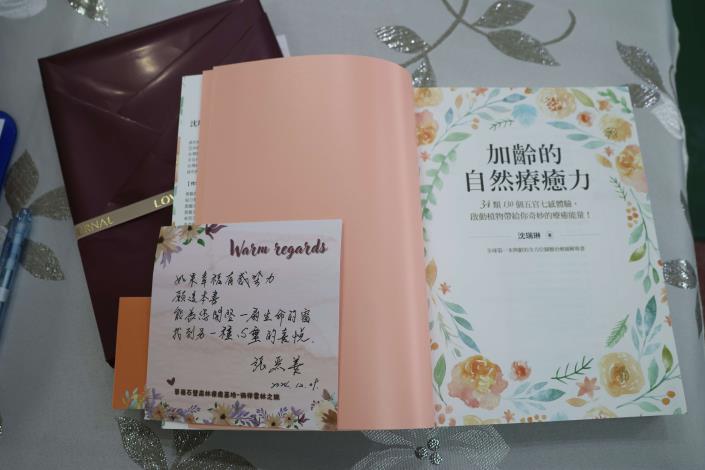 張麗善贈送《加齡的自然療癒力》一書,鼓勵女校長關愛自己,體驗自然療癒能量。(記者廖承恩翻攝)