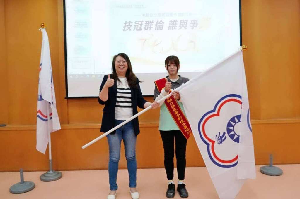 ▲中彰投分署劉秀貞分署長將代表勝利的旗幟交至誓師代表手中，祝福選手們旗開得勝 。（記者林明佑翻攝）