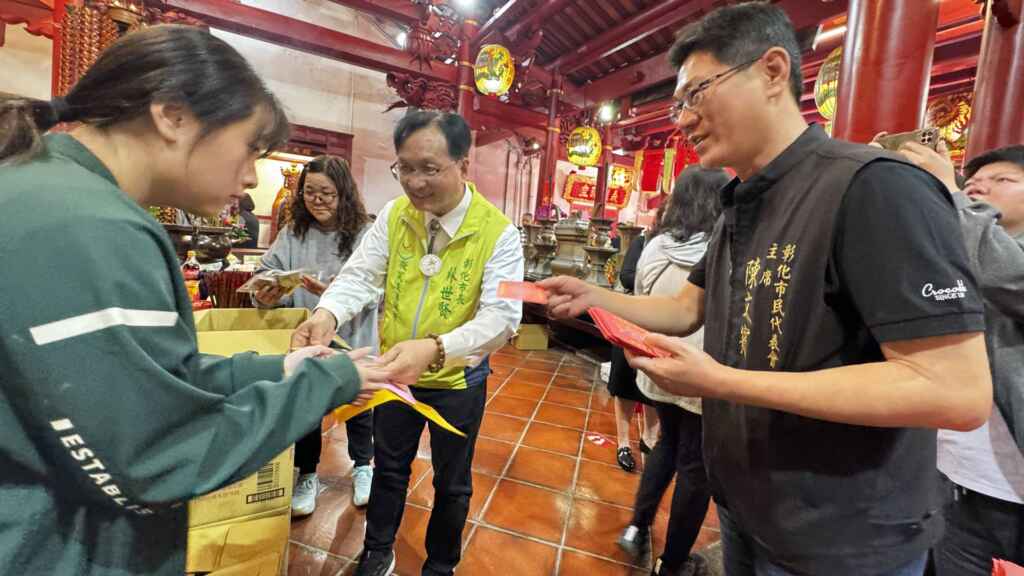 ▲彰化市關帝廟文昌帝君聖誕祝壽暨為考生點燈祈福活動，彰化市長林世賢、彰化市民代表會主席陳文賓一同發給每位參考者一組「文昌運組」與「開運文創品」」，期許所有考生都能應考順利、高中金榜。（記者林明佑攝）