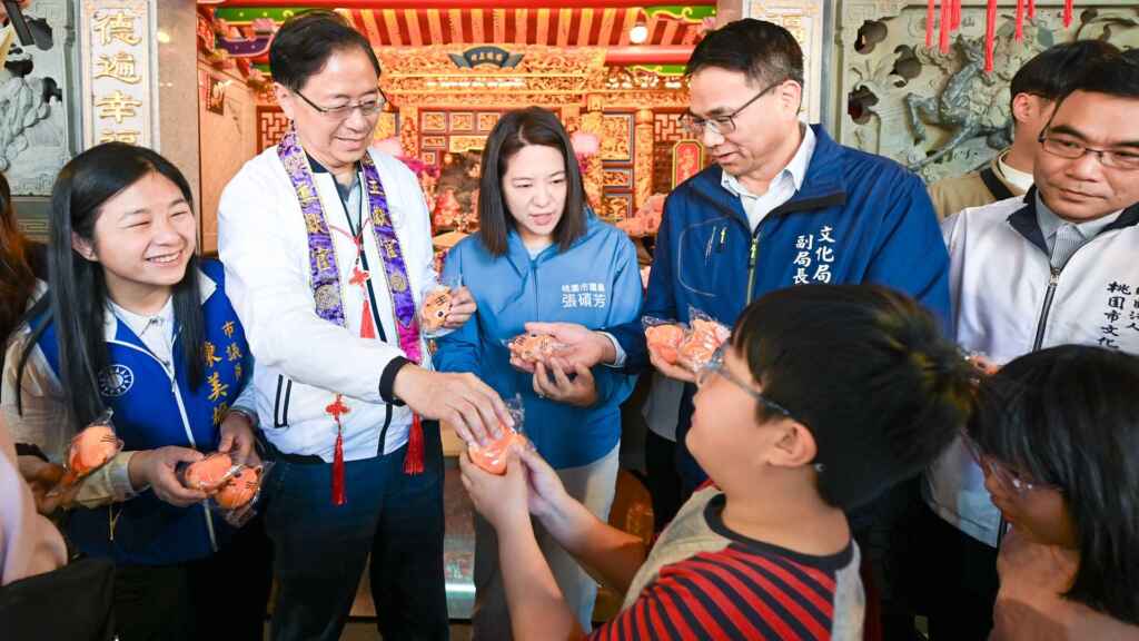 ▲桃園市長張善政與出席貴賓發送限量「虎爺造型杯套」予小朋友。（桃園市文化局提供）