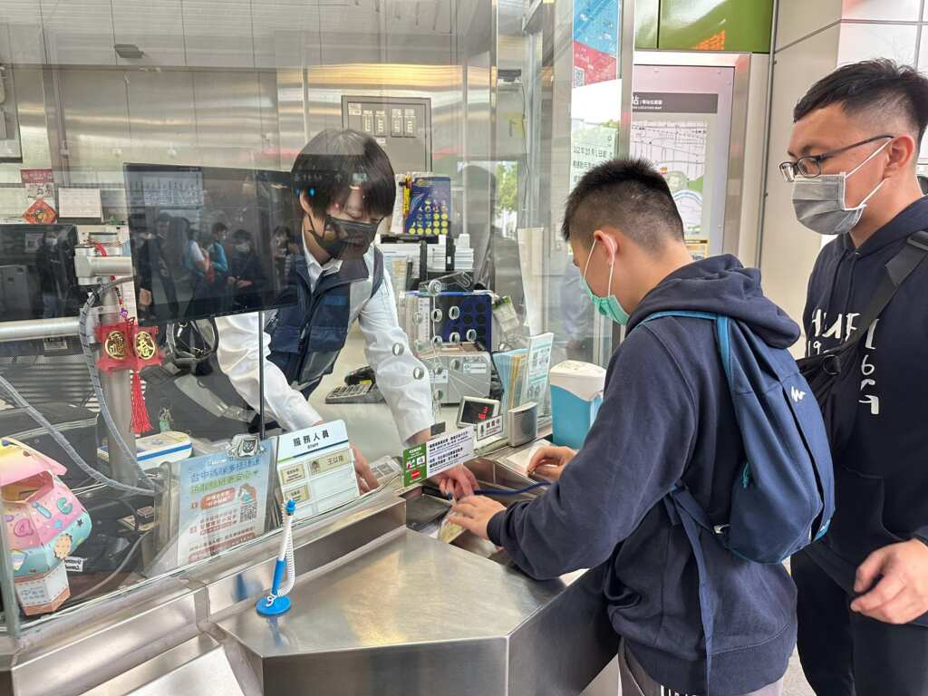 惠明學生在車站詢問處與站務人員互動。