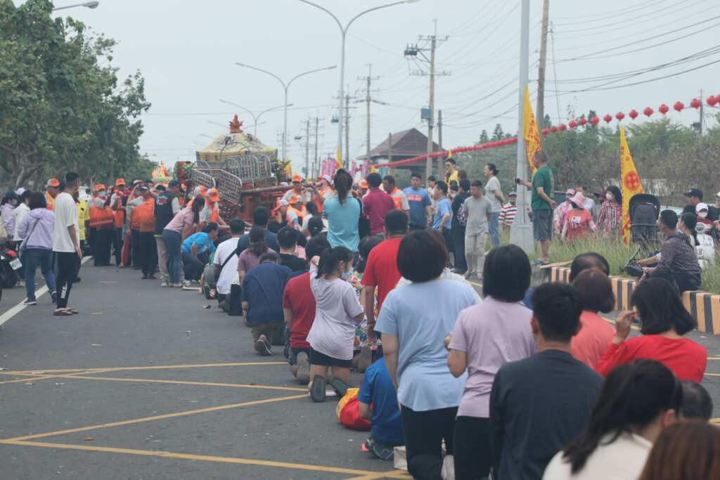信眾都會趴跪在路中,等待神轎通過「鑽轎腳」以求平安。