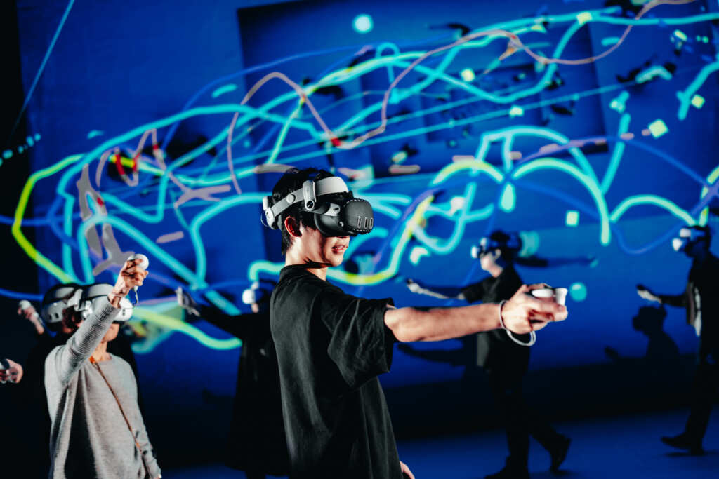 ▲2025 NTT Arts NOVA—狠劇場《自由遊戲—XR身體音樂計畫》，VR手把化作一支自由揮灑的畫筆，筆觸在空間中漂浮，轉化成各式色彩線條。（攝影：林峻永，臺中國家歌劇院提供）