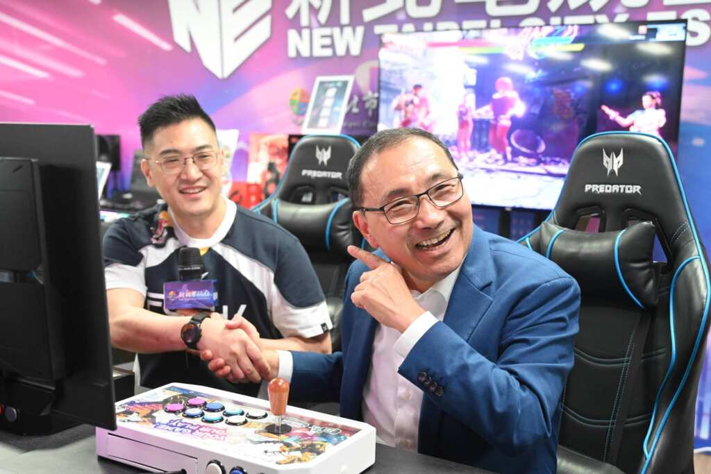 ▲2022杭州亞運銀牌得主GamerBee（向玉麟）帶領侯友宜體驗快打旋風的樂趣。（新北市政府提供）