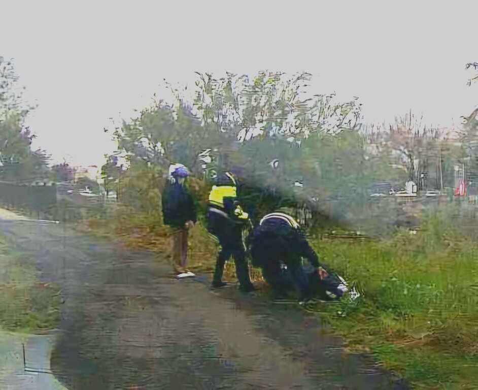員警徒手拉繩合力將重達百公斤的機車從邊坡拖回道路。(記者廖承恩翻攝)