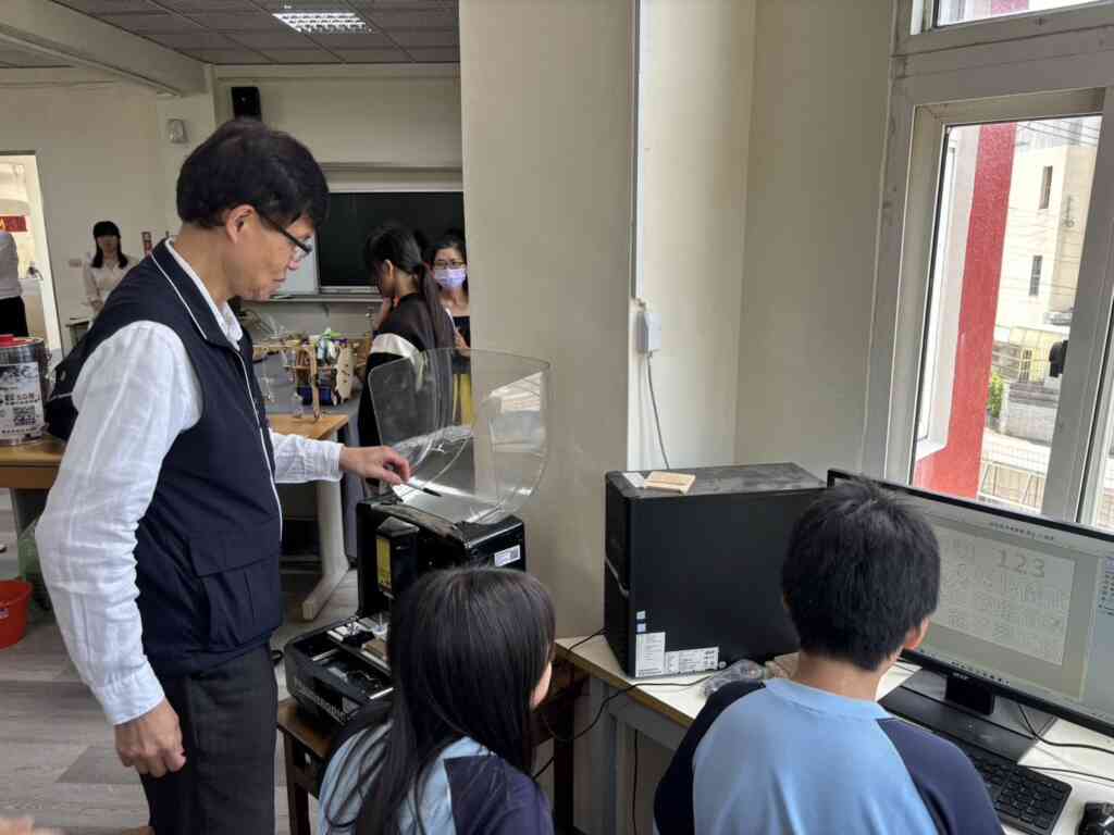 ▲ 教育局長蔣偉民現場與學生合作DIY手機架。（台中市政府提供）