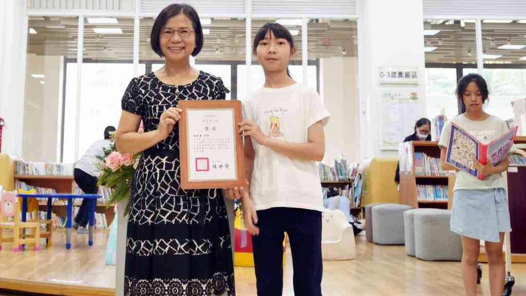 ▲彰化市立圖書館館長李逢時頒發參展忠孝國小美術班同學獎狀。(記者林明佑攝)