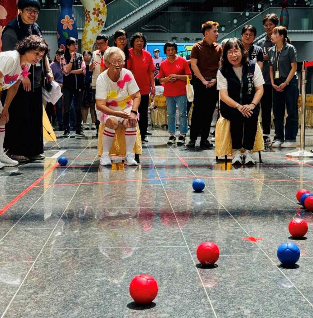 ▲廖局長與84歲黃阿嬤體驗地板滾球。（記者廖妙茜翻攝）