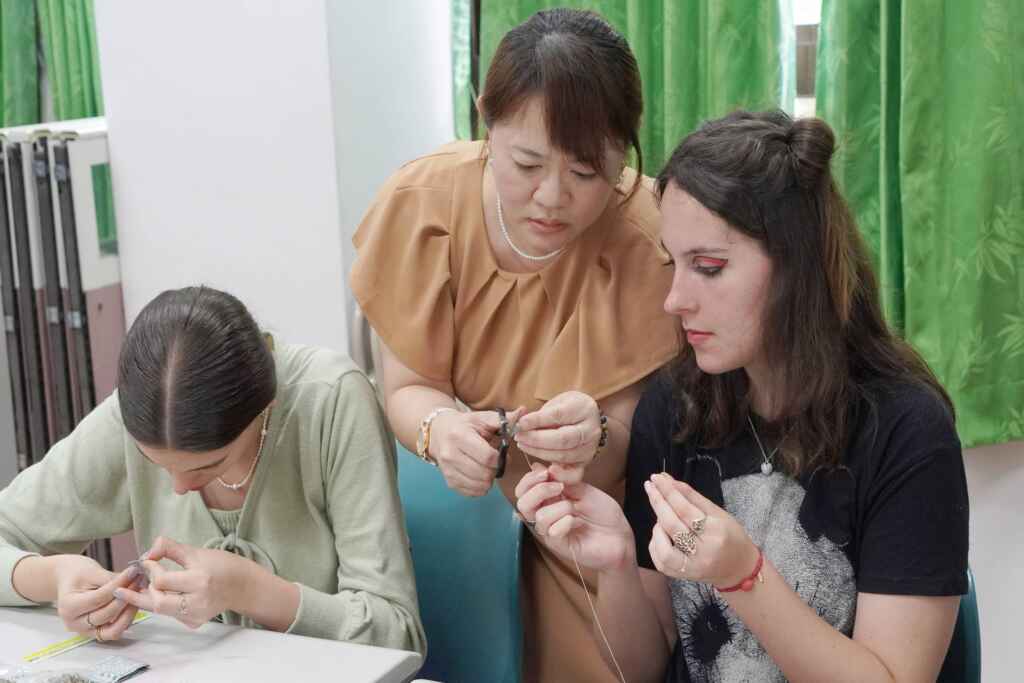 ▲大葉大學藥保系張淑微老師(中)教導境外學生製作香包。(大葉大學提供)