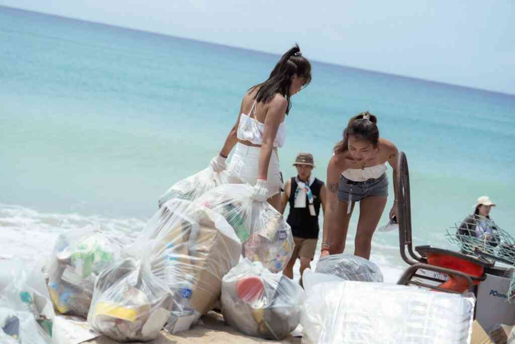 ▲近百人不畏烈日沿著海岸沙灘清理垃圾，半天就清理了500餘公斤的垃圾。（屏東縣政府提供）